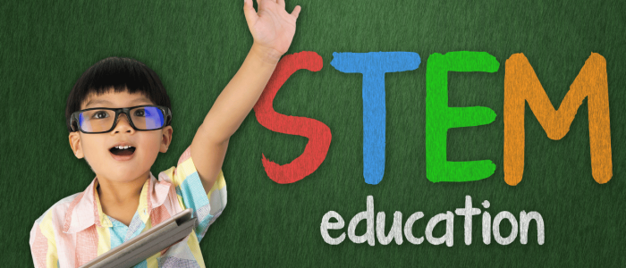 Boy raising hand in front of background that reads STEM education