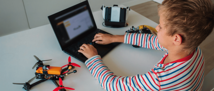 Student programming a drone with a laptop computer