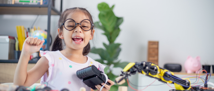Girl happy after assembling a robot arm