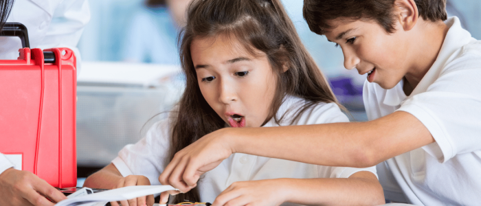 Two elementary students amazed by electronic circuit