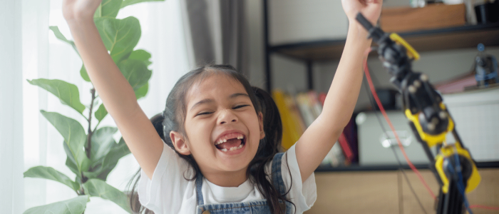 Triumphant girl after assembling a robot arm