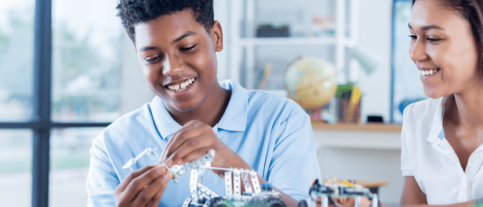 High school students assembling a robot from an erector set