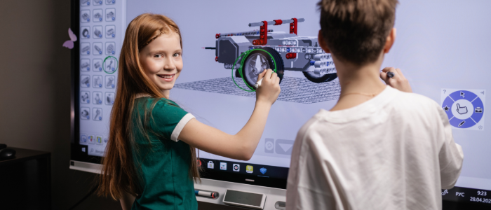 Girl and boy working on 3D model using a smart board